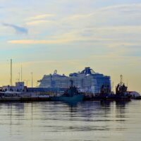 Un barco de MSC Cruceros atracado en el puerto de Málaga, con el faro de La Farola a la izquierda