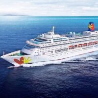 Recreación del Buenavista con la librea de Corazul Cruceros, con su nombre en la proa y el logotipo del corazón y la flor en el casco, navegando en mar abierto