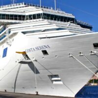 El Costa Serena de Costa Cruceros amarrado en puerto, con el nombre del barco visible en la proa