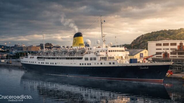 TELETIPO de noticias de Cruceros 15 El transatlántico portugués Funchal, con su casco azul y la chimenea amarilla, atracado en el puerto de Gotemburgo al atardecer.