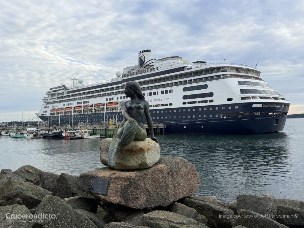 Nerida, la sirena de bronce de Richard Klyver, sobre una roca del paseo de Eastport, con el ms Volendam al fondo.