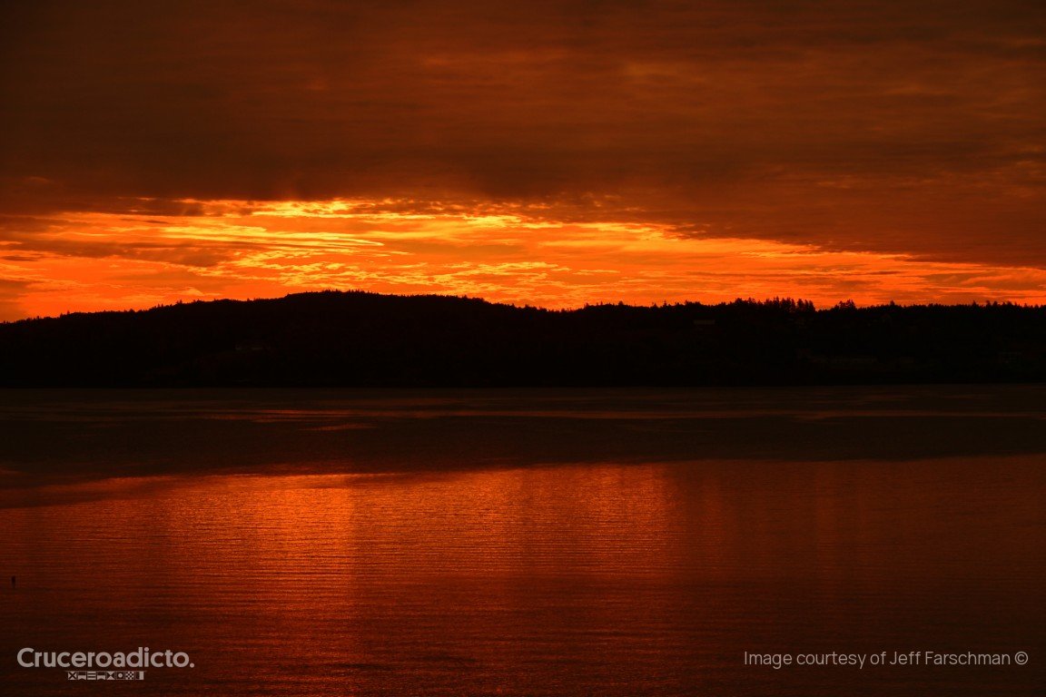 Cielo naranja intenso sobre una costa boscosa en silueta y el agua de la bahía de Passamaquoddy.