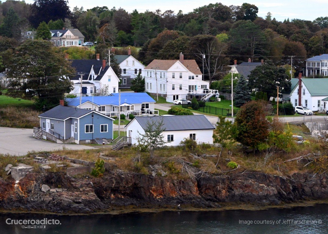 Casas de madera blancas y azules sobre un acantilado rocoso en la costa de Eastport, Maine.