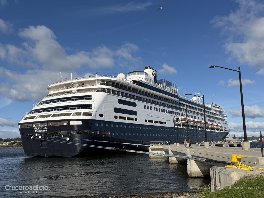 Popa del ms Volendam amarrado en el muelle de Sydney, Nueva Escocia, con cielo azul y nubes.
