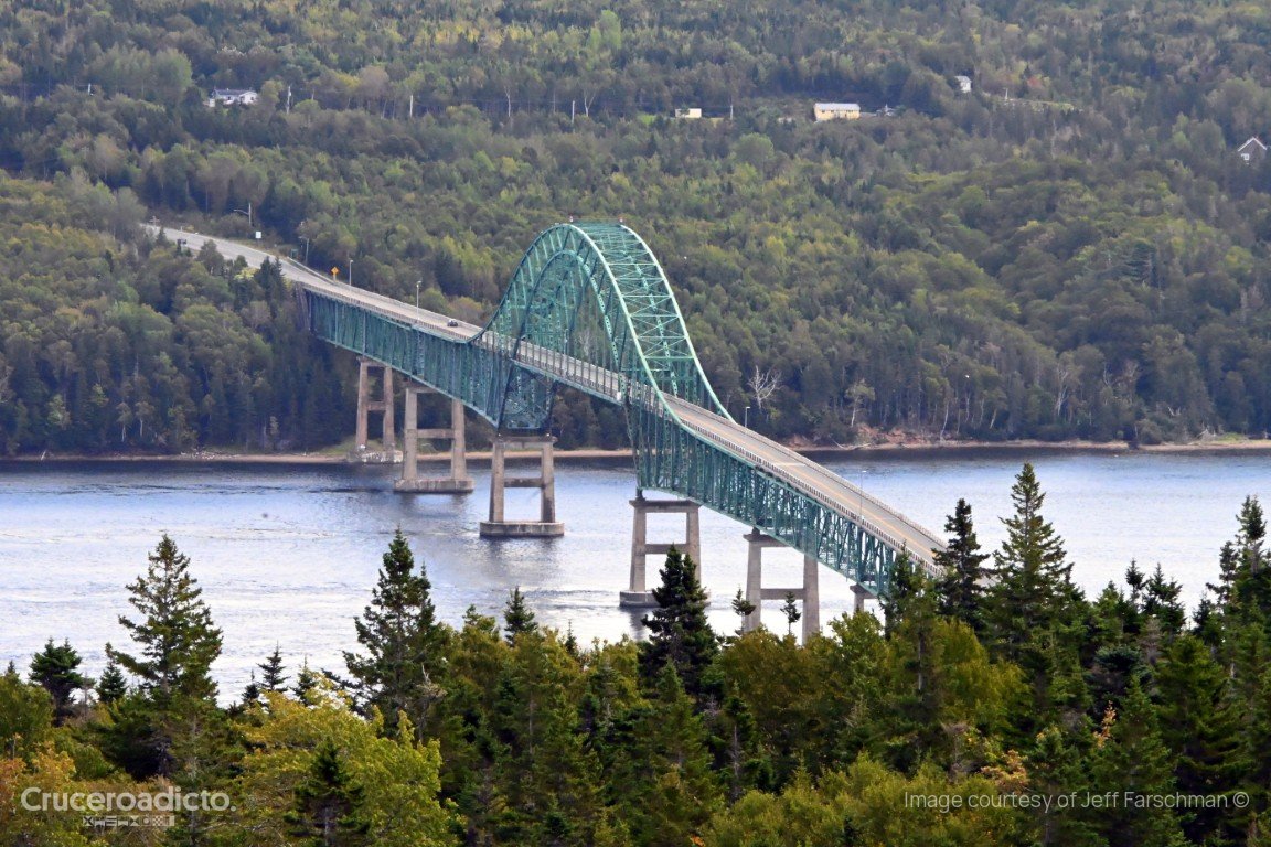 Puente de arco metálico sobre un brazo de agua rodeado de bosque en la isla de Cape Breton, Nueva Escocia.