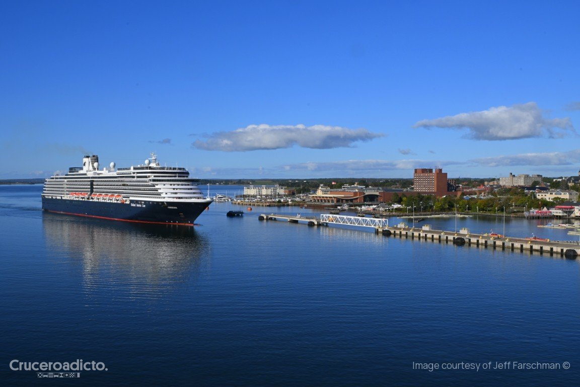 El crucero ms Zuiderdam navegando frente al muelle de Charlottetown, con la ciudad al fondo.