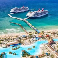 Vista aérea de Celebration Key, el destino de Carnival Cruise Line en las Bahamas, con tres barcos atracados en su muelle y lagunas de baño junto a la playa