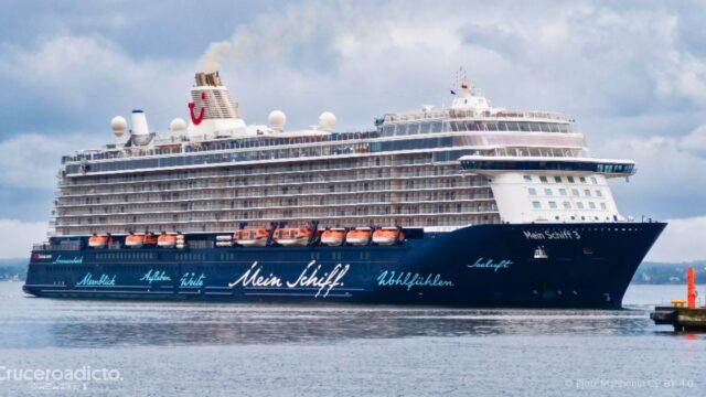 El Mein Schiff 3 de Mein Schiff TUI Cruises navegando cerca de un muelle con el cielo nublado