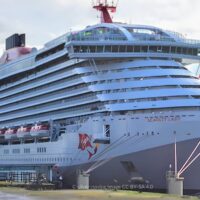 El Scarlet Lady de Virgin Voyages atracado en un muelle, con sus cabos de amarre tensos hasta los norays. Imagen de silver-novice, CC BY-SA 4.0.